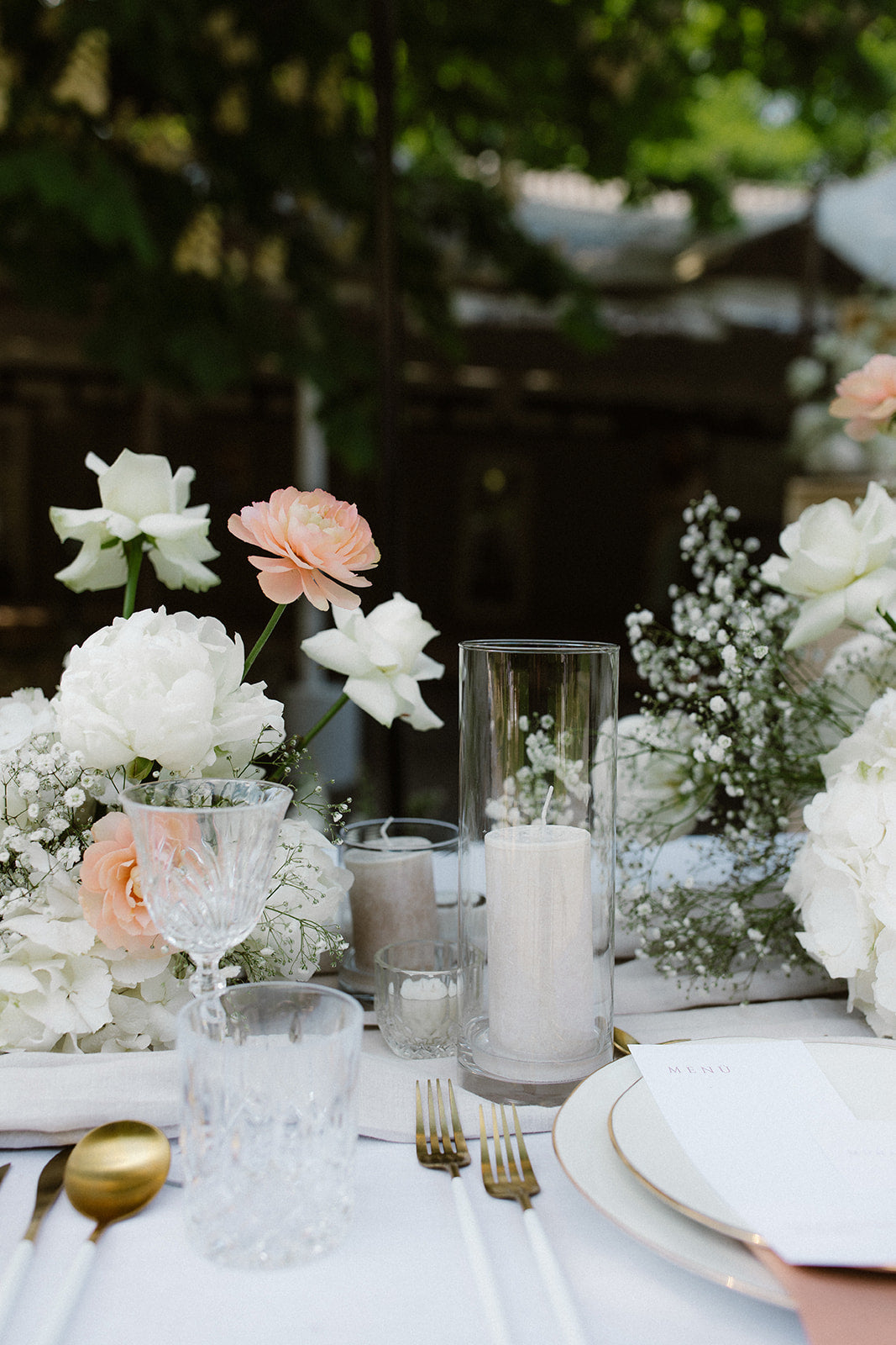 DIY-Hochzeitstisch mit weißen und rosa Blumen sowie hohen Kerzen in Glaszylindern. Diese romantische Hochzeitsdekoration zeigt zarte weiße und rosa Blüten in Kombination mit eleganten, hohen Kerzen in Glaszylindern. Die harmonische Anordnung sorgt für eine gemütliche und edle Atmosphäre auf dem Hochzeitstisch.