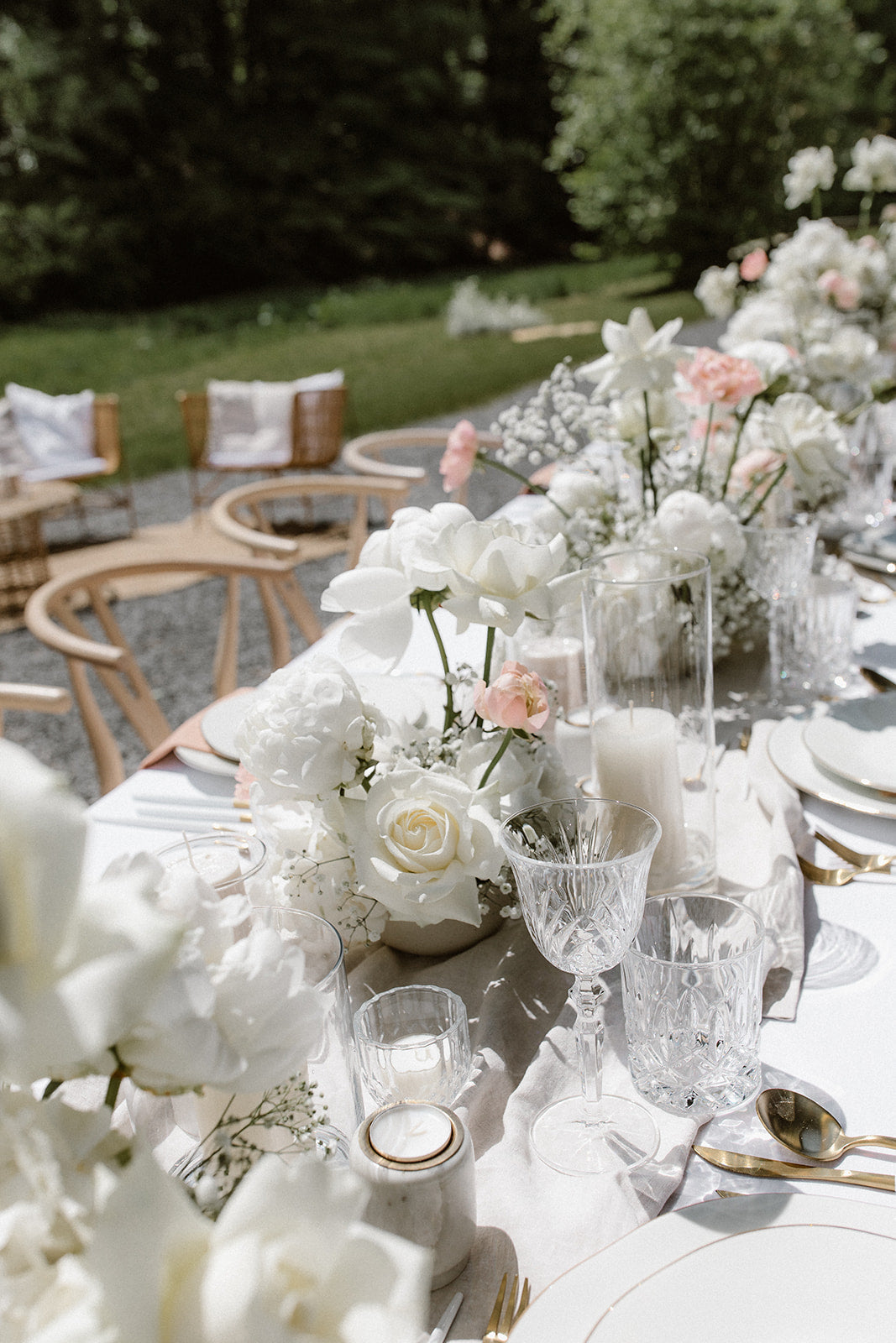 Romantisch, ästhetische Hochzeitstischdekoration im Garten mit weißen Blumen, edlen Gläsern und zarten Details. Diese romantische Tischdekoration für eine Gartenhochzeit besticht durch weiße Blumenarrangements, edle Kristallgläser und fein abgestimmte Details. Die dezente Farbpalette und elegante Gestaltung sorgen für eine stilvolle Atmosphäre im Freien.